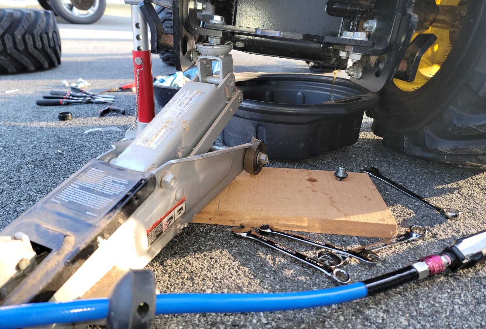 Draining engine oil into a pan during a scheduled service